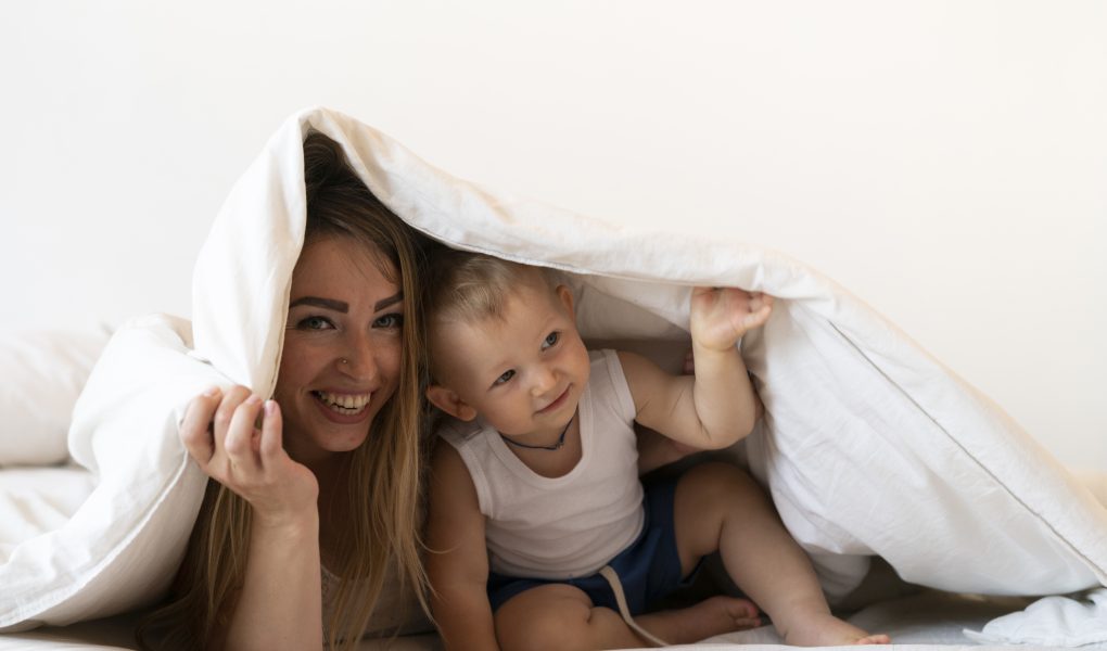 Widok z przodu matki z synem pod kocem